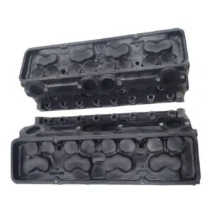 Pair of engine cylinder heads on white background.
